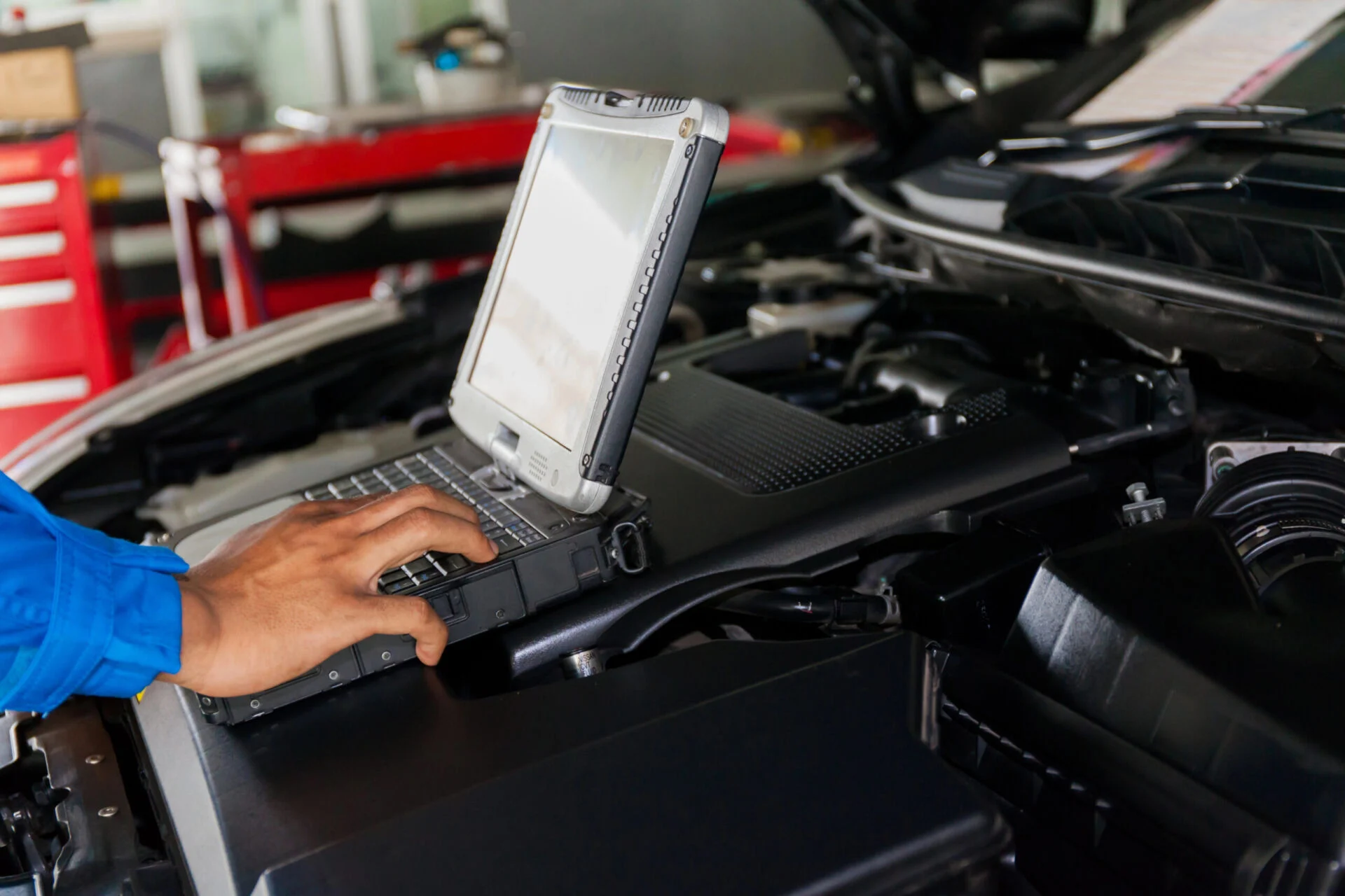 Mechanic using diagnostic computer.