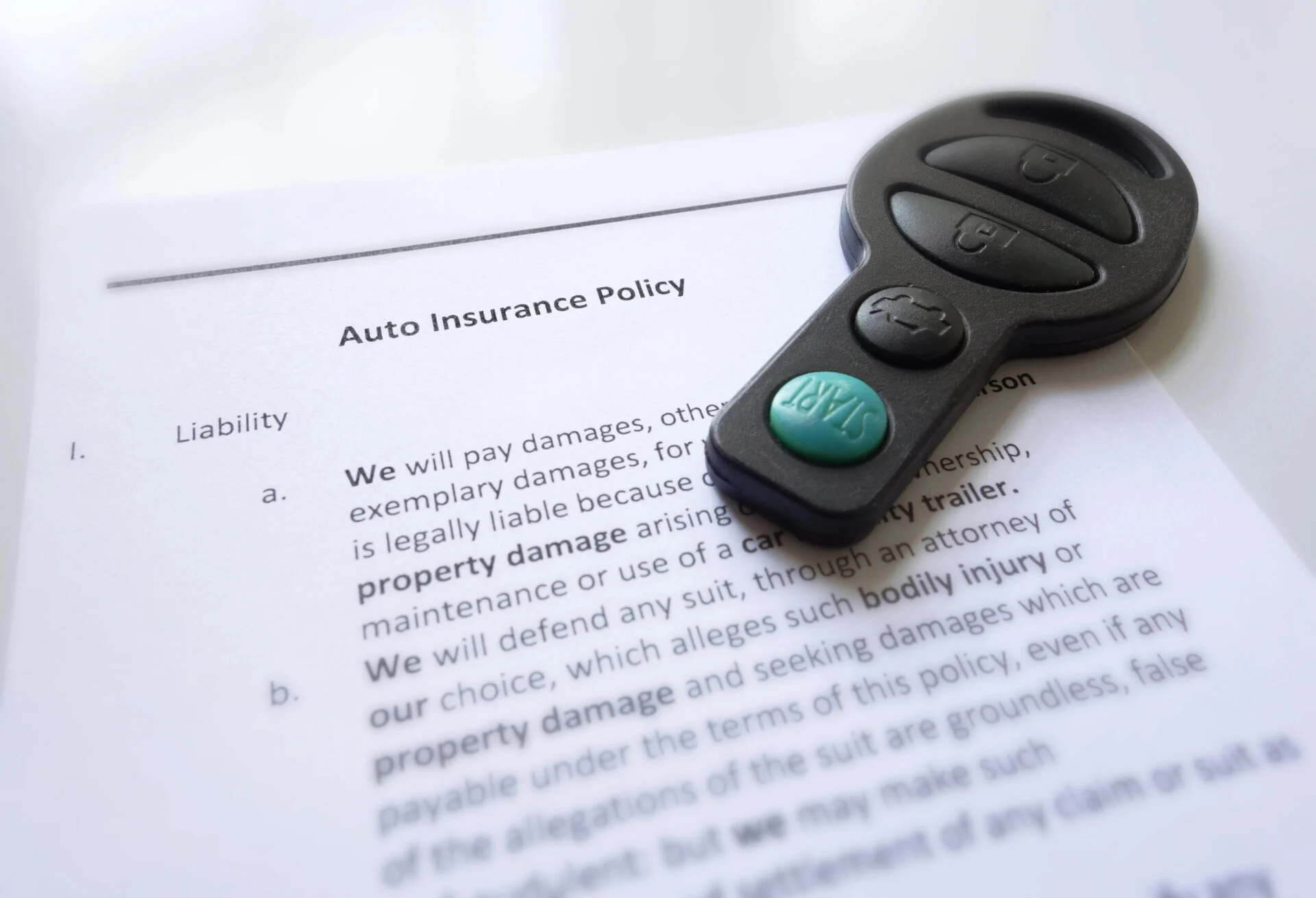 Auto insurance forms with a key set on top of them.