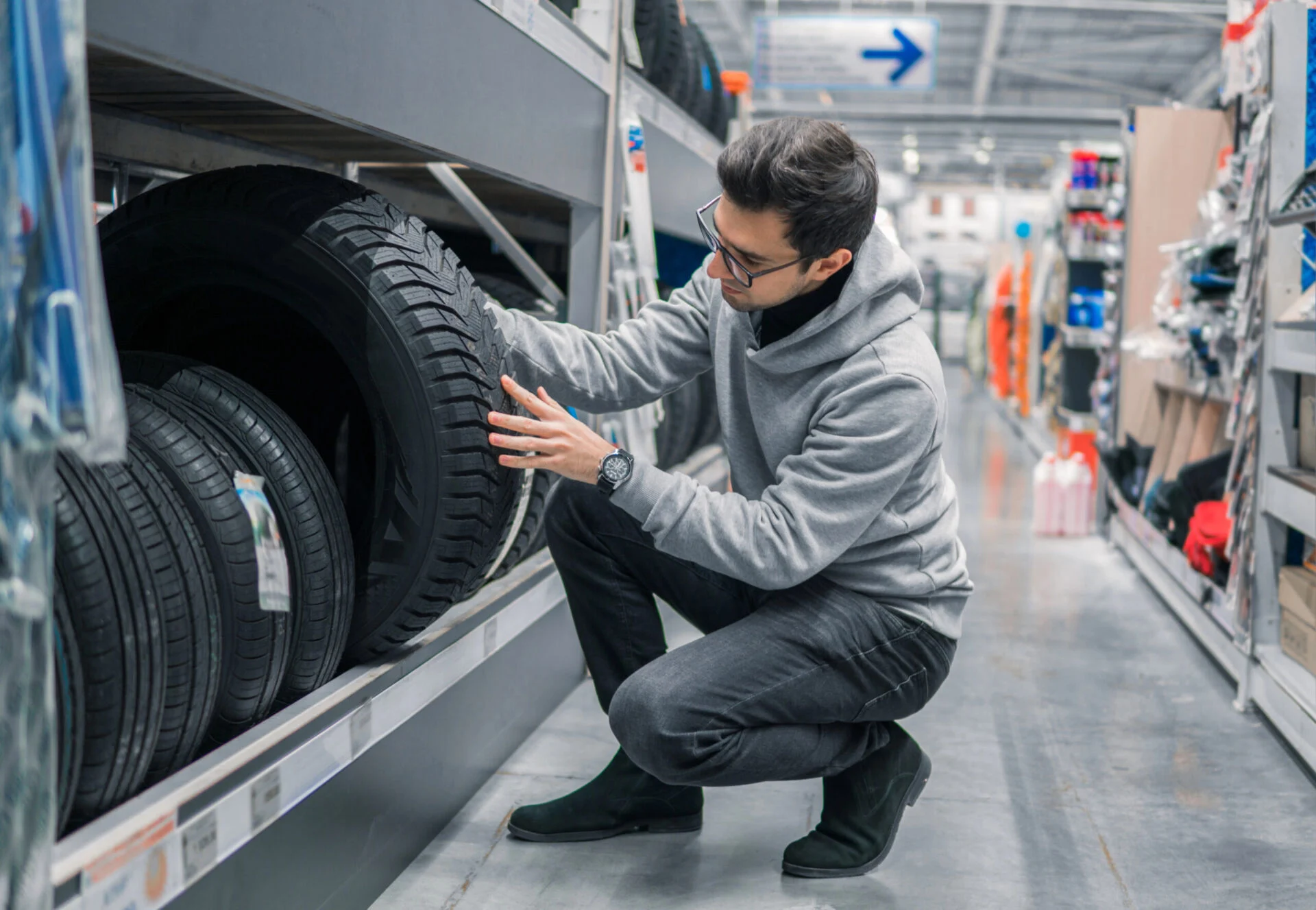 Male customer shopping for new car tires in store.