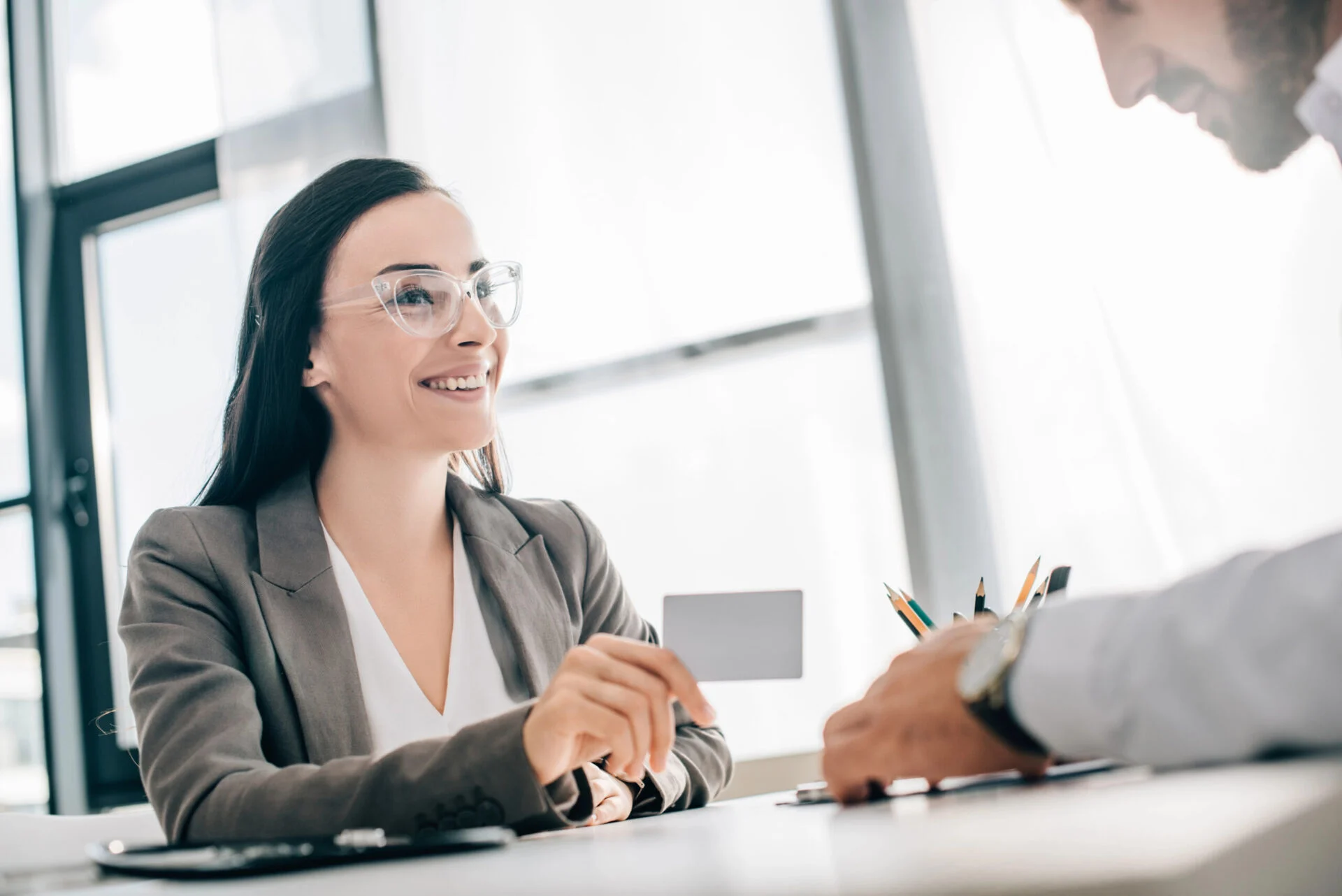 Woman handing blank card to man over table