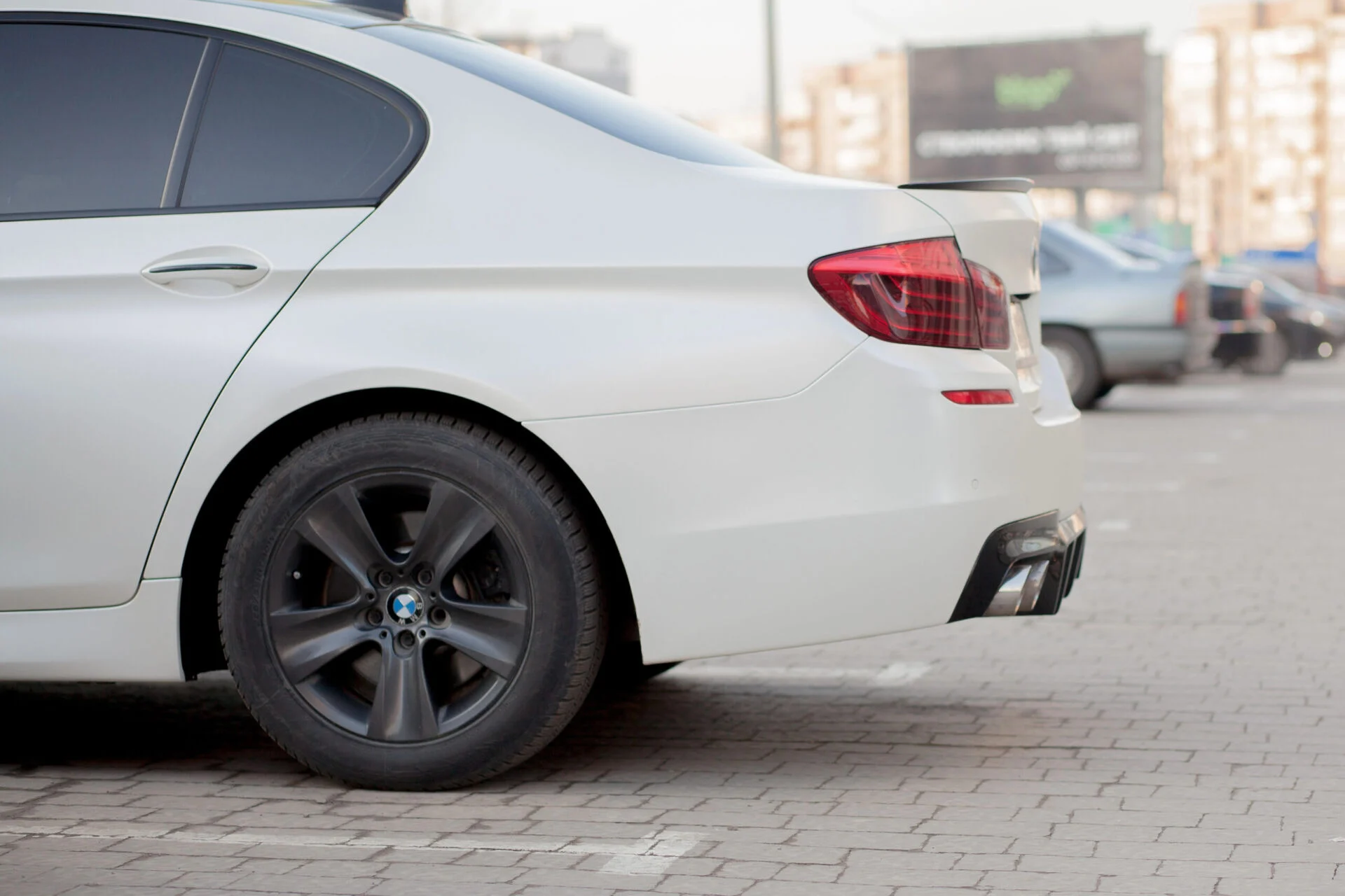 Rear side-view of white sedan.