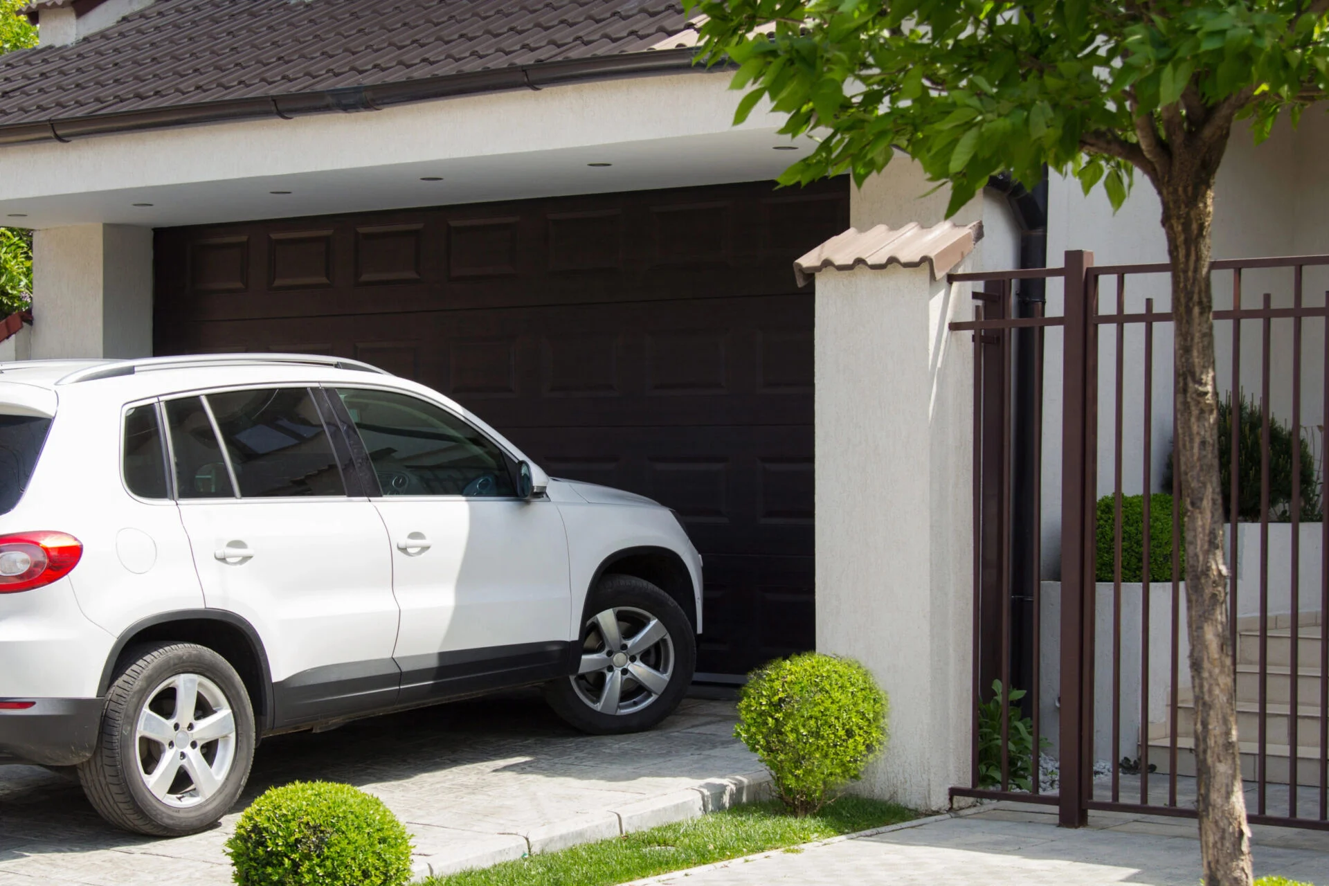 A white vehicle sits in the driveway of a home