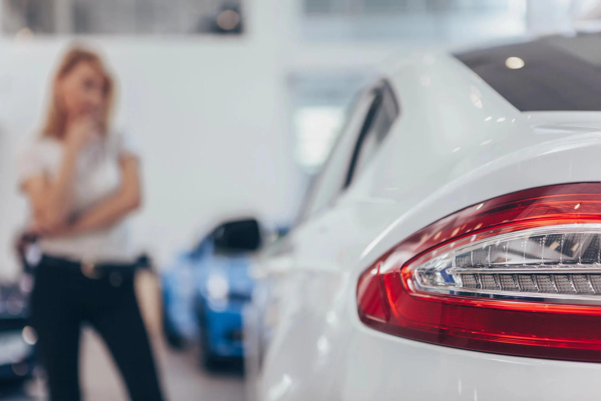 Close up of young woman debating in front of a car.