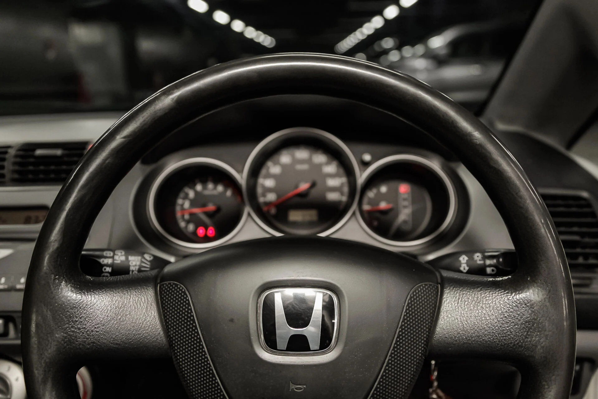 Dark photo of a Honda steering wheel