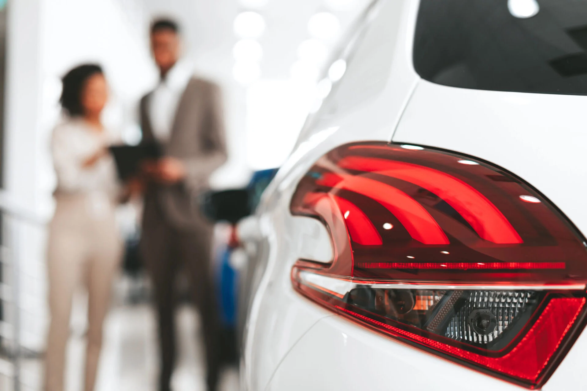 Person talking to car salesman in dealership