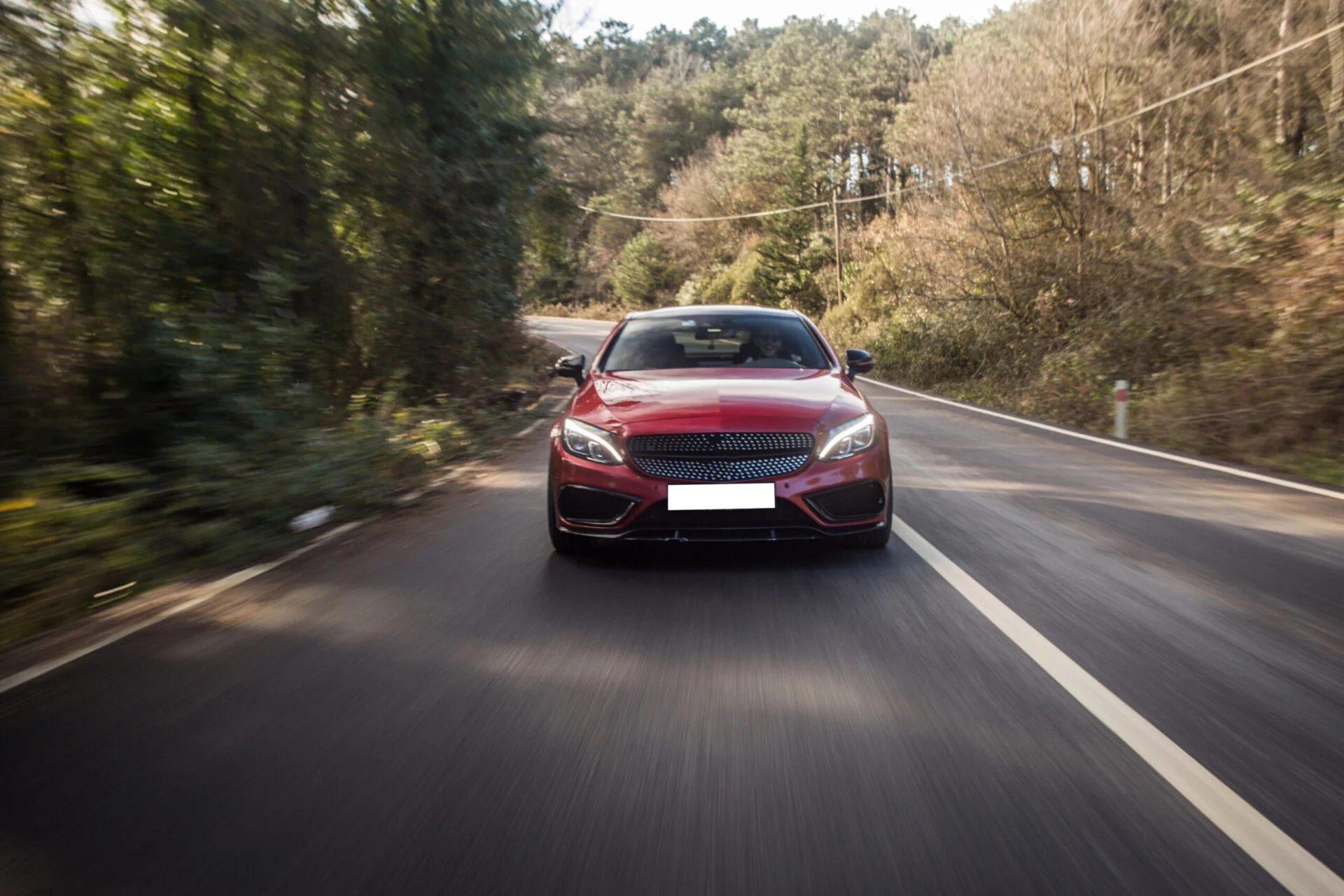 Front view of red car driving on highway.
