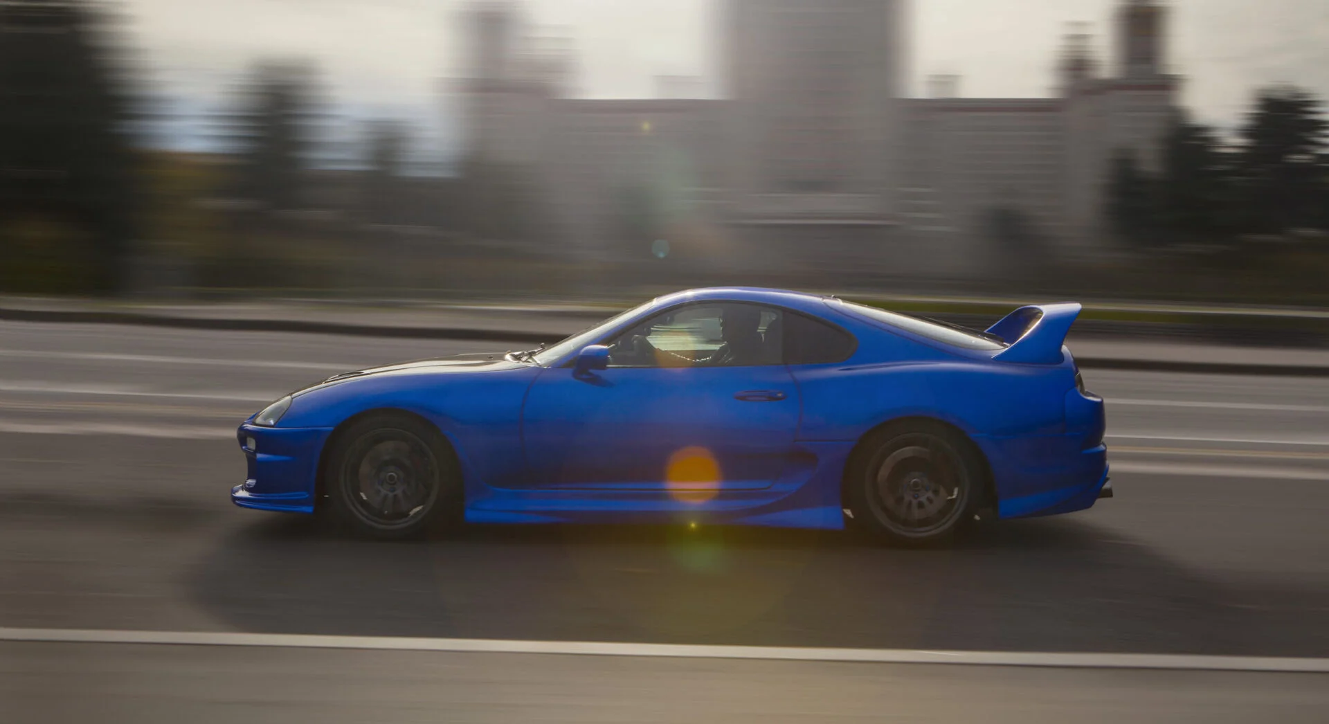 A blur sports car going fast down the road