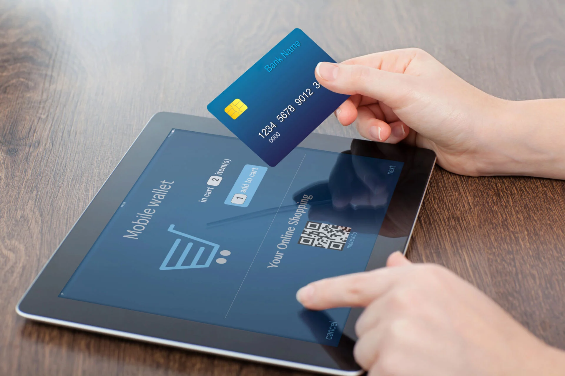 Person holding a bank card while using a tablet to do online shopping