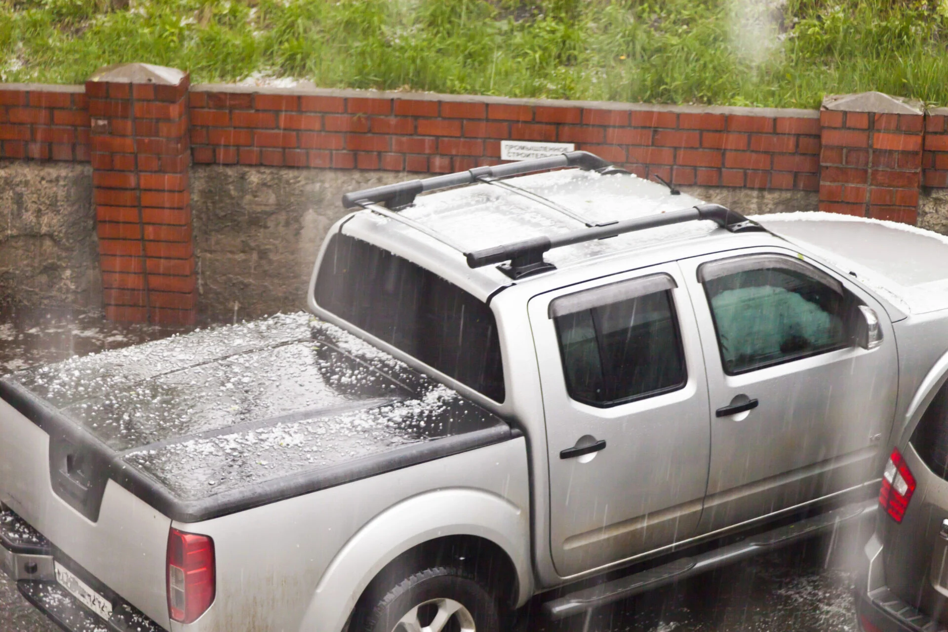 Rain and hail fall on a truck.