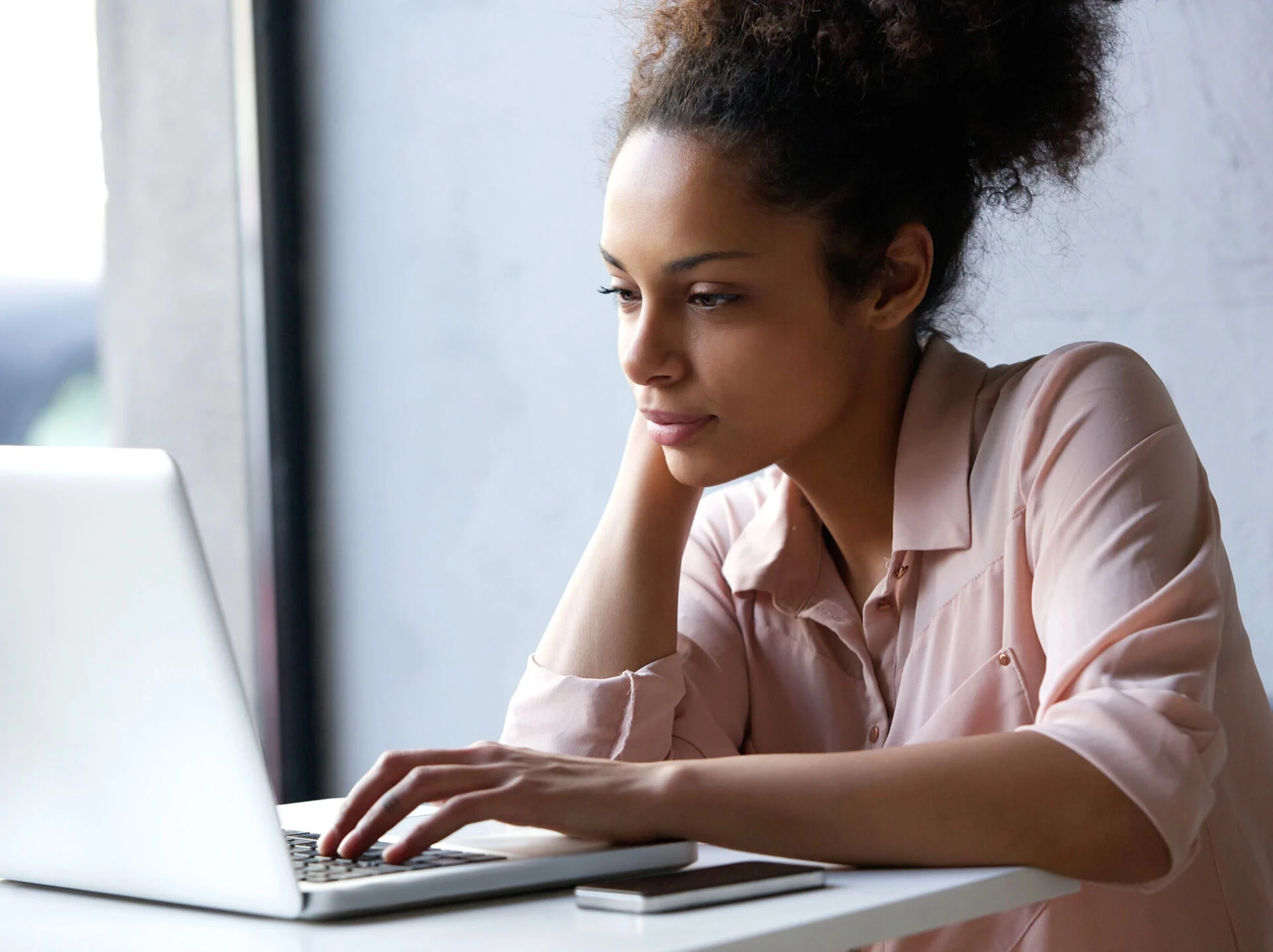 Young woman looks at a laptop computer on a desk