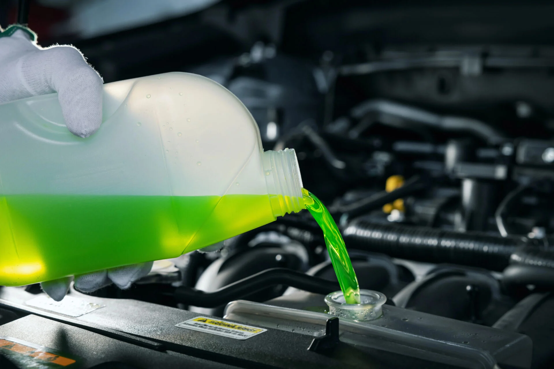 Person refilling coolant in car