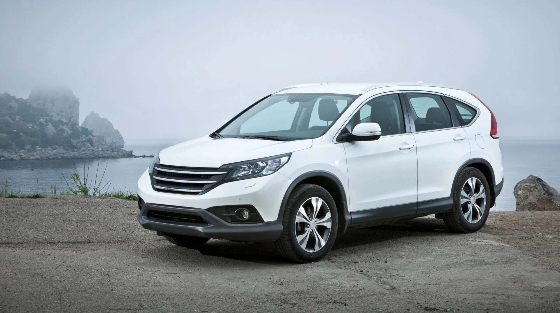 Side view of a white vehicle parked near water