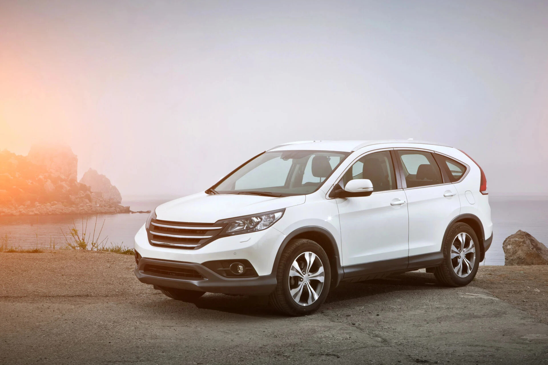 White SUV parked in front of lake