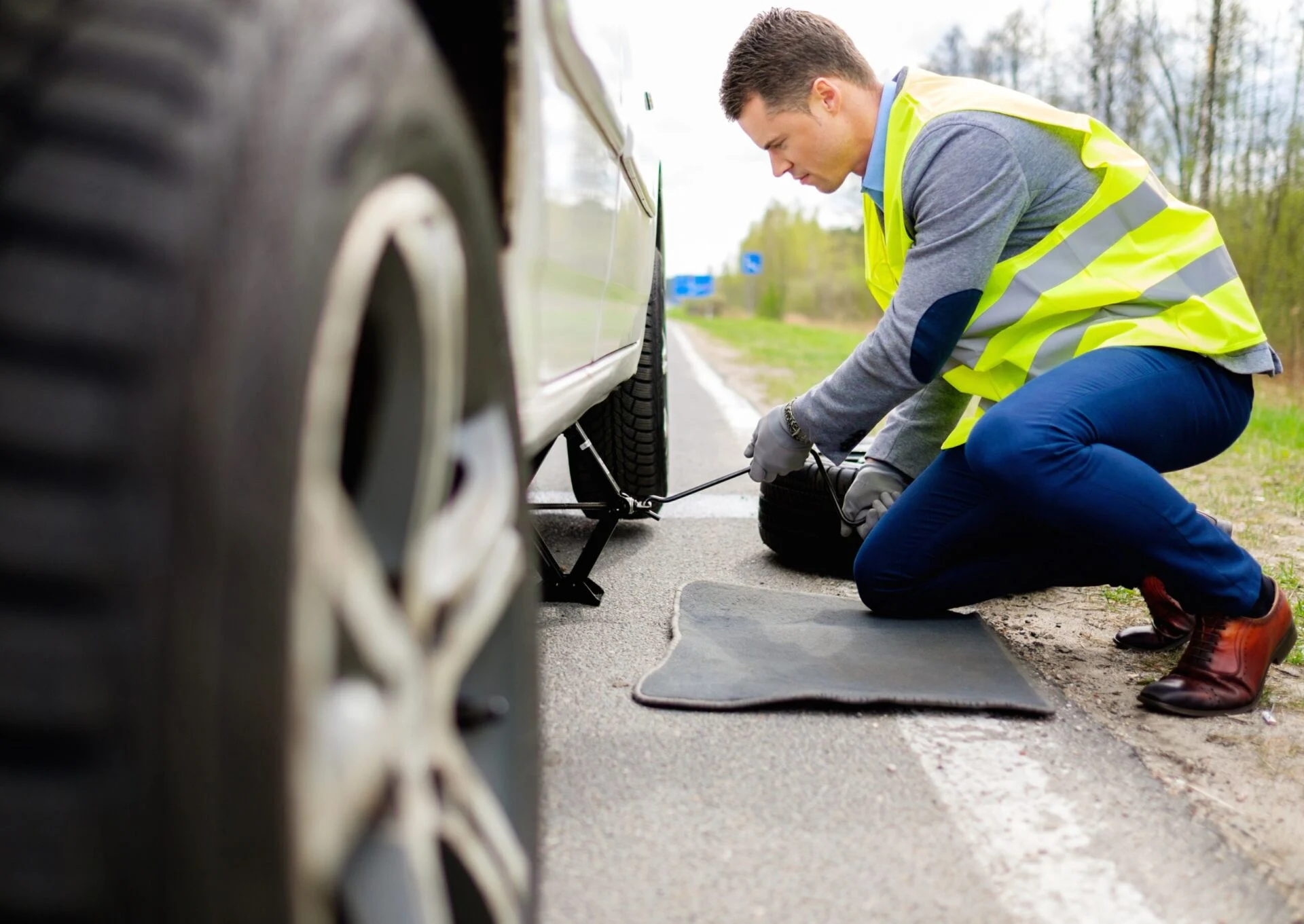 Man changing tire on a roadside