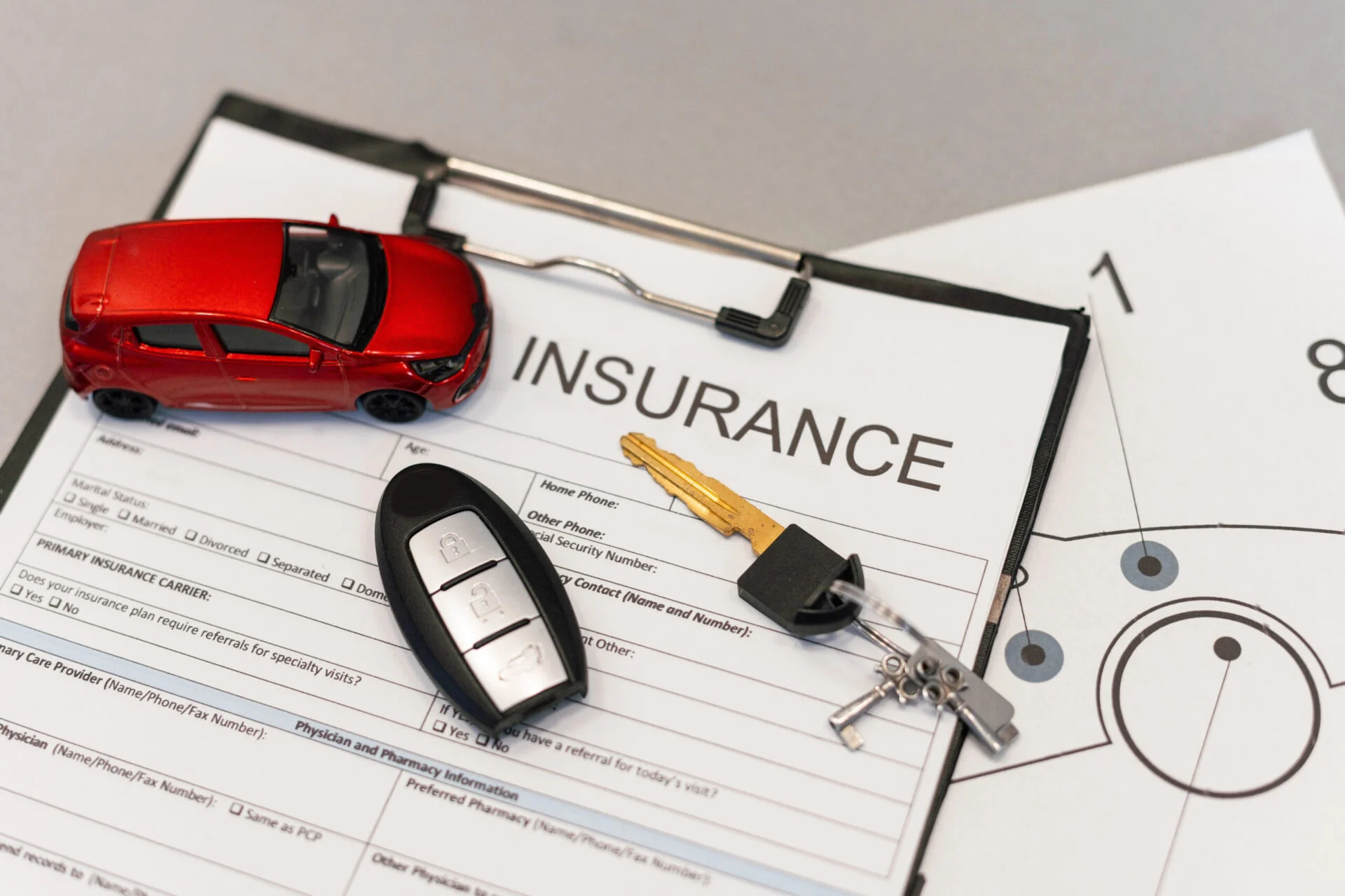 Car keys sit on top of an insurance form