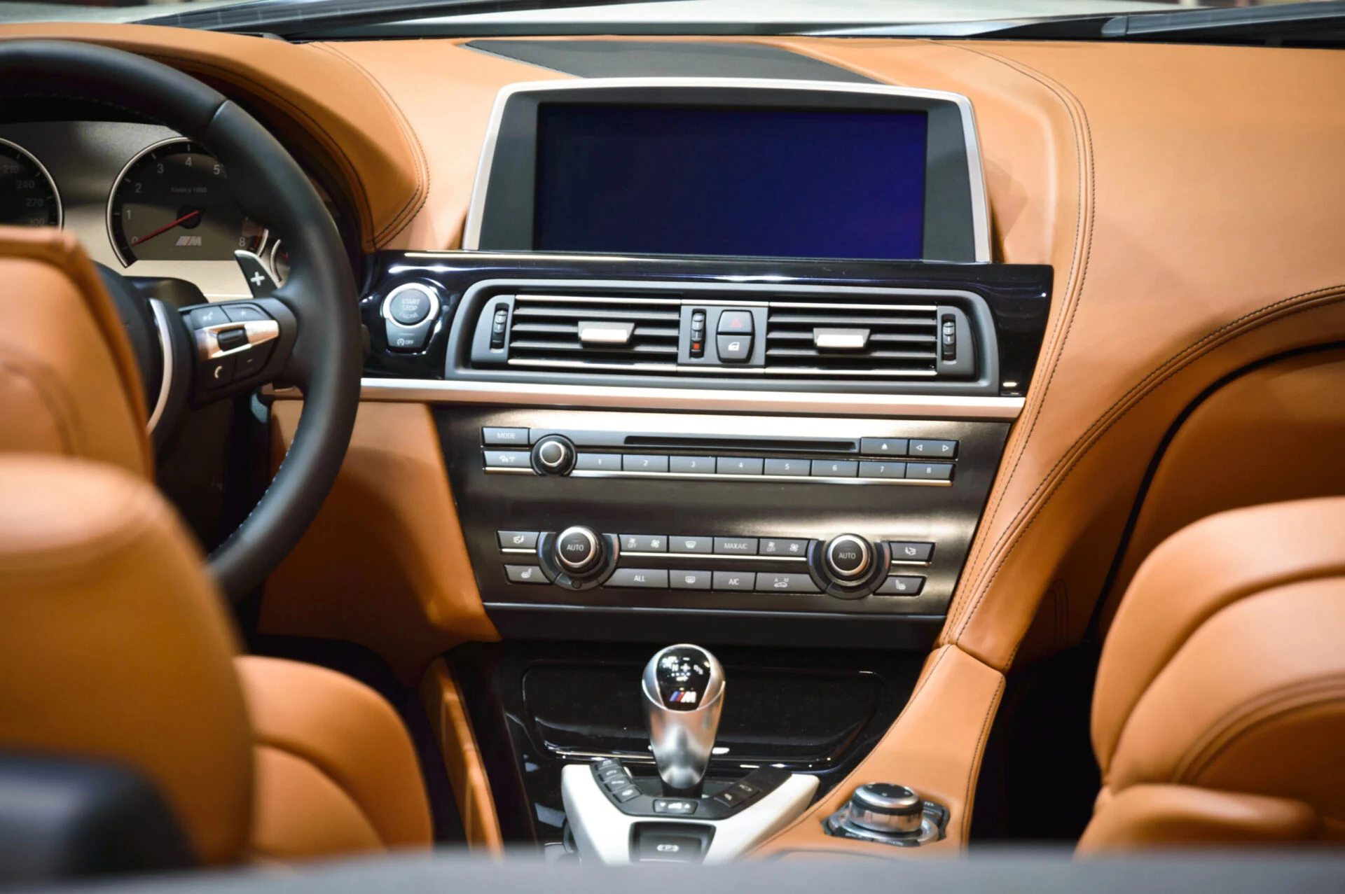BMW media console with tan orange interior.